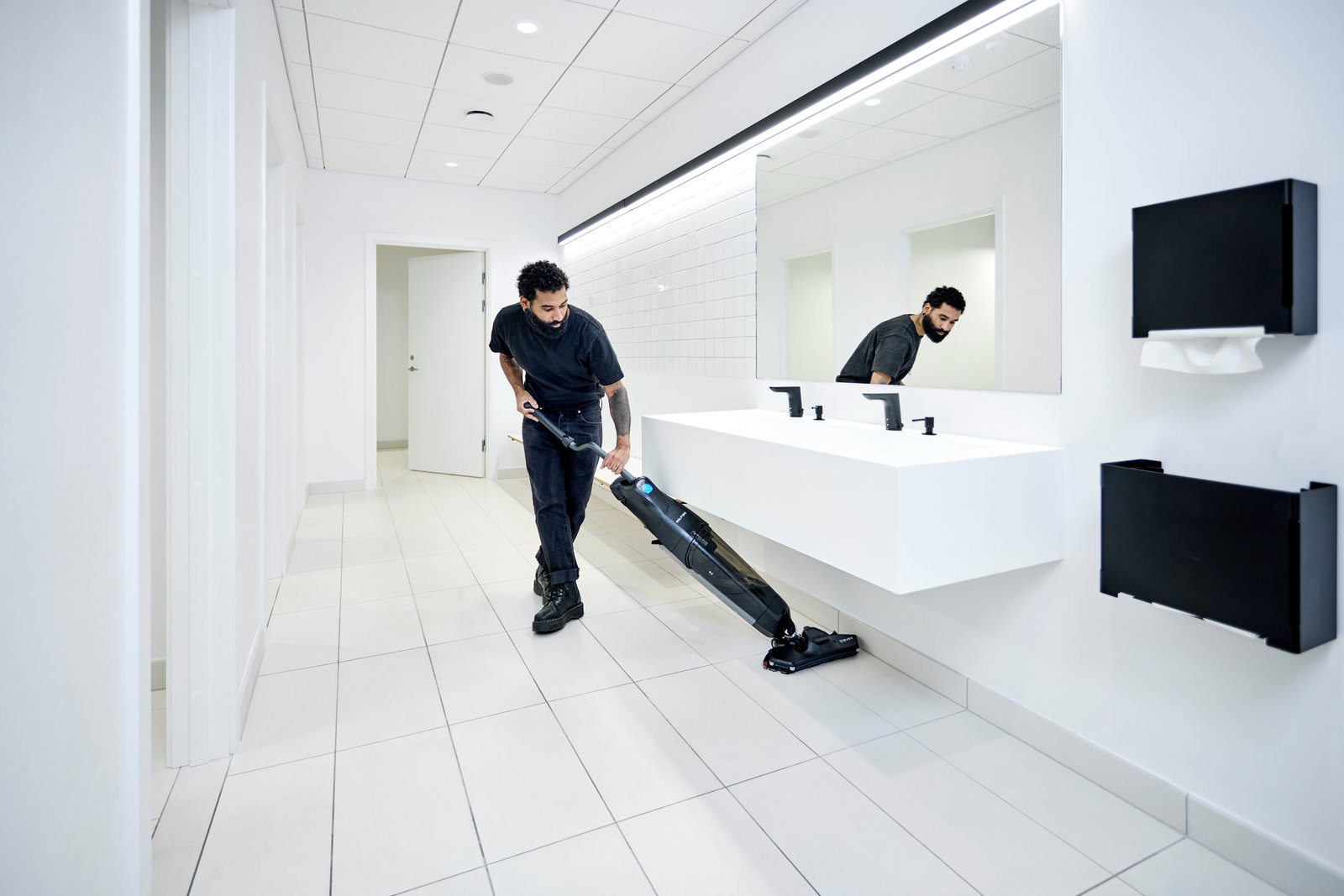 Nilfisk Dryft compact scrubber dryer working in a washroom
