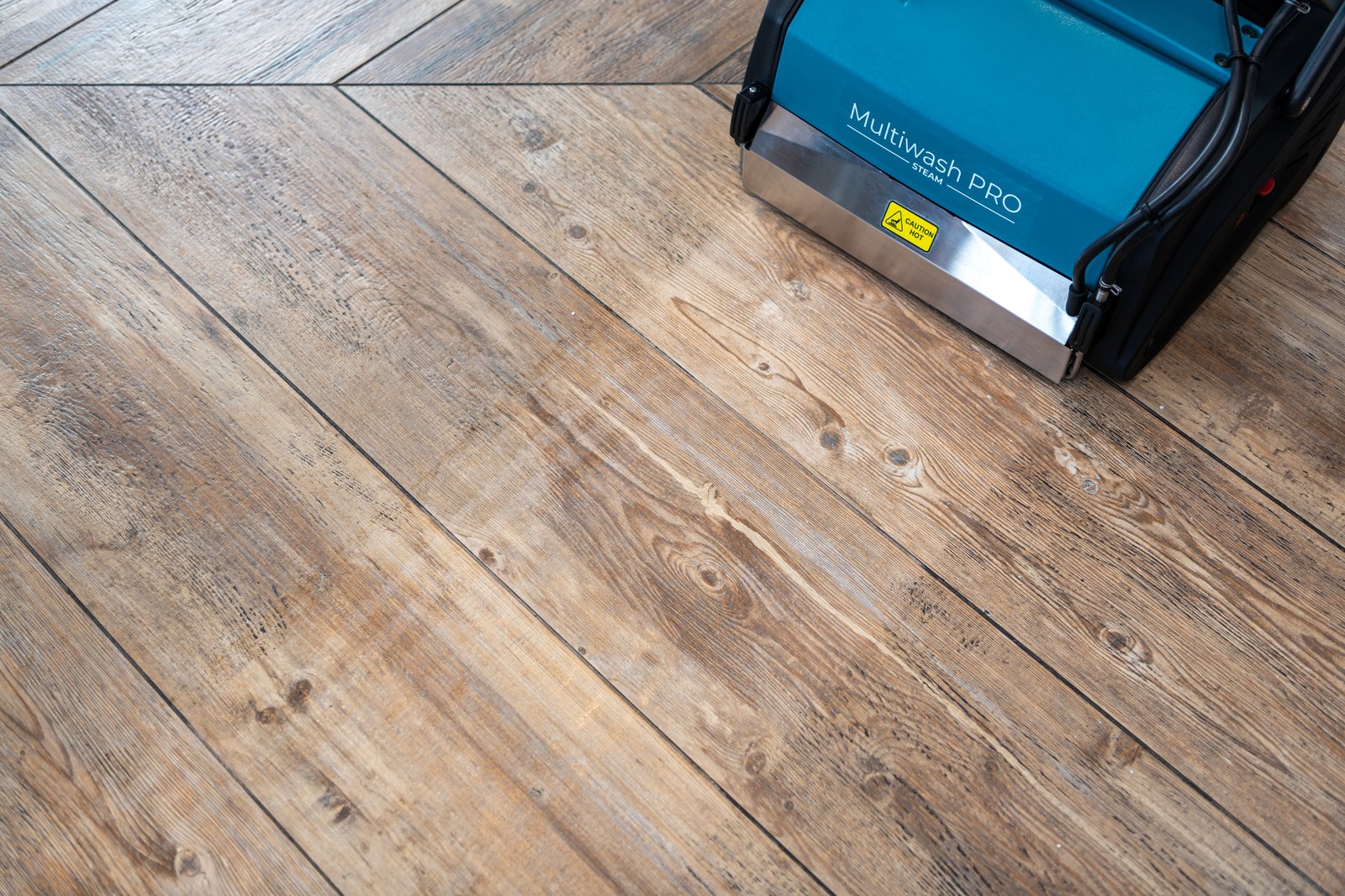 Truvox Multiwash PRO Steam revealing the original colour of a wood-effect floor mid-clean