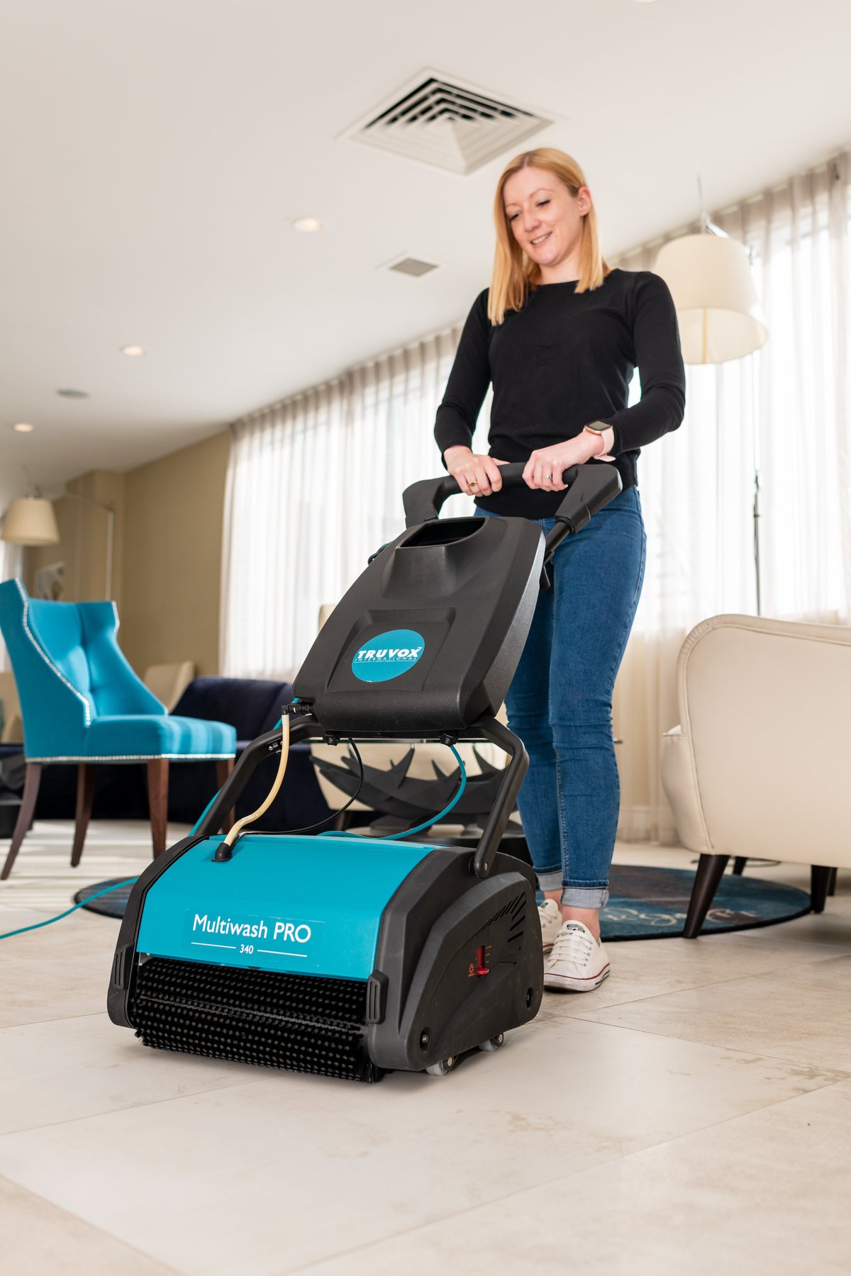 Truvox Multiwash PRO 340 cleaning the wood floor of a care home communal lounge with operator